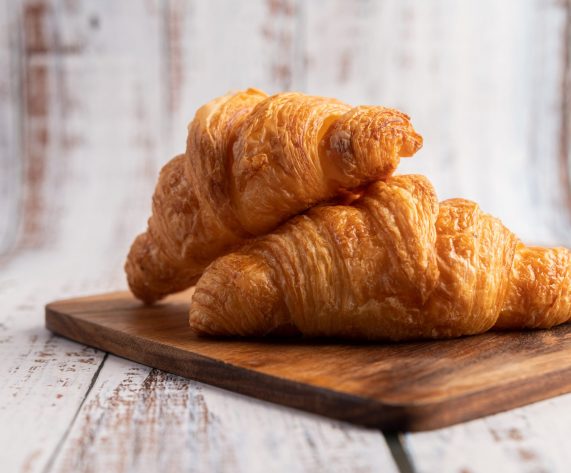 Croissants on a wooden cutting board. Selective focus.